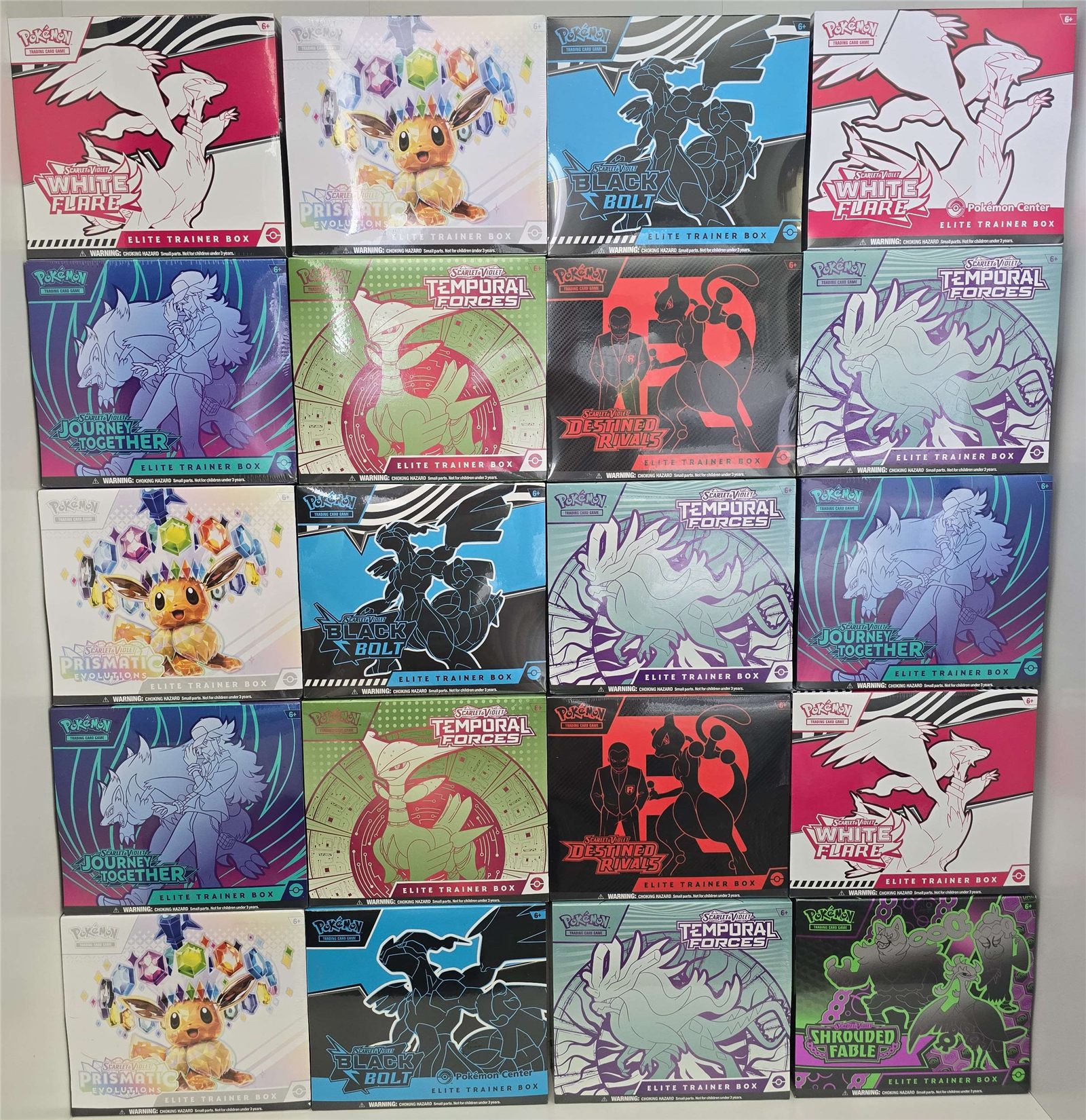 A wall display of Pok&eacute;mon Elite Trainer Boxes including White Flare, Black Bolt, Prismatic Evolutions, Journey Together, Temporal Forces, Destined Rivals, and Shrouded Fable